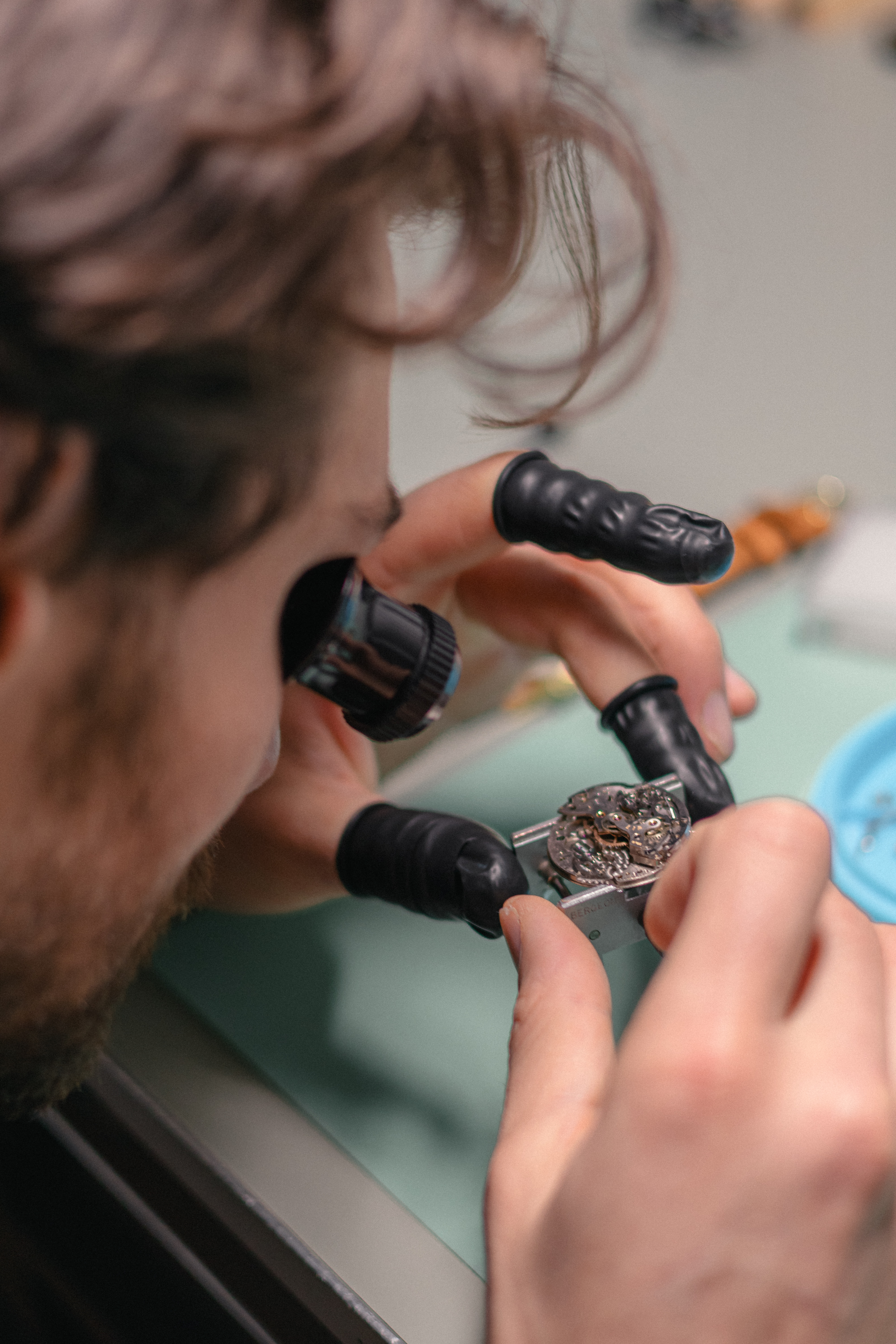 Horloger au travail sur un mouvement de montre